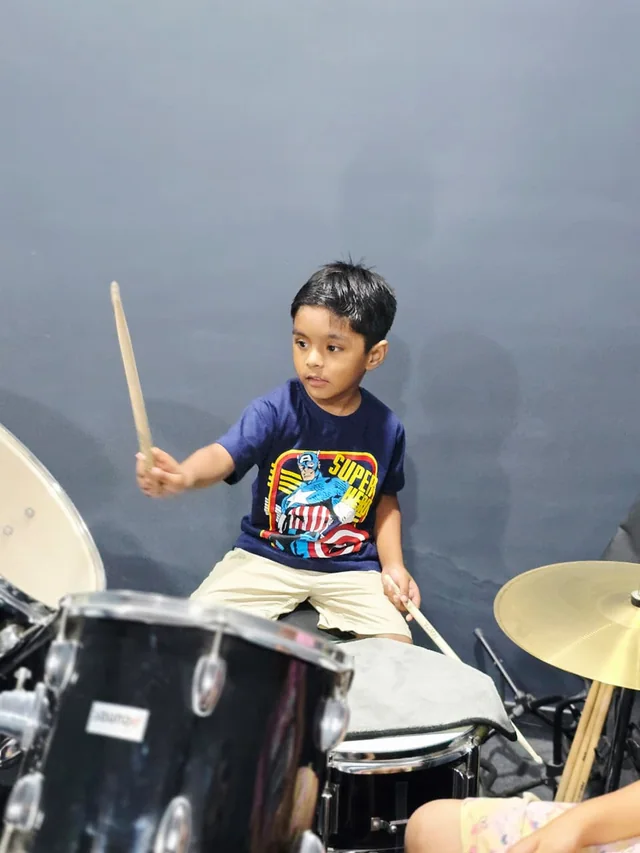 A young student playing the drum kit at Grace Music Academy